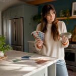 Woman evaluating kitchen color samples in modern kitchen