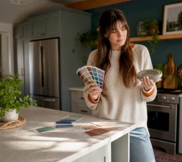 Woman evaluating kitchen color samples in modern kitchen